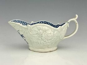 A Worcester relief moulded sauce boat, circa 1765, the interior decorated in blue and white with the