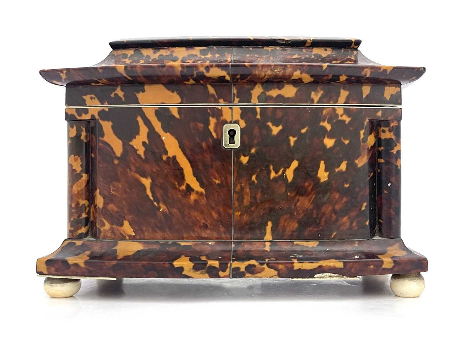 A Regency tortoiseshell tea caddy, circa 1820, of bow-fronted sarcophagus form with silver wire