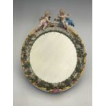 A Meissen figural and florally encrusted mirror frame, oval form, acanthus lappet and foliate