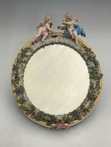 A Meissen figural and florally encrusted mirror frame, oval form, acanthus lappet and foliate
