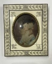 An 18th century portrait miniature painted to depict a young bewigged woman with black ostrich