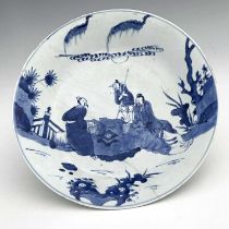 A Chinese blue and white plate, Kangxi, everted rim, painted with scholars and attendant in a