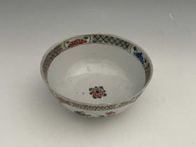 A Chinese famille verte bowl, painted with panels of prunus and chrysanthemums, the trellis border