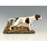 A Doulton figure of a Pointer dog, HN 2624, modelled alert in thicket with a tree stump, 30cm long