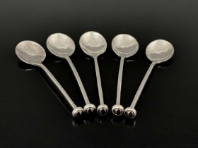 A set of five Arts and Crafts style silver and garnet set spoons, marked Ag.999, planished with