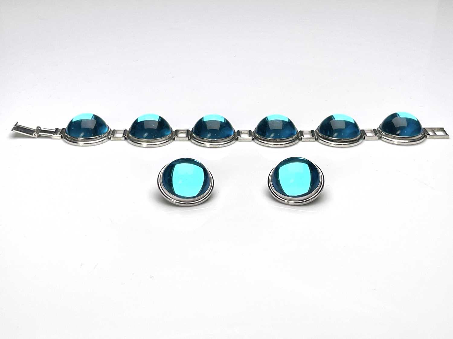 Lalique, a blue glass cabochon bracelet and earring set, hemispherical roundels in white metal