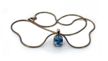 An 18 carat go;d and blue topaz pendant on chain, the oval cut stone in a claw setting, 7.8g