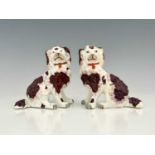 A pair of Staffordshire porcelain dog figures of King Charles spaniels, brown patination, modelled