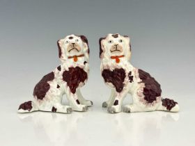 A pair of Staffordshire porcelain dog figures of King Charles spaniels, brown patination, modelled