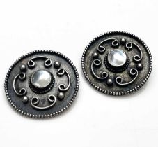 A pair of Arts and Crafts silver and mother of pearl buttons, circular form applied with coiled C