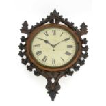 A Gothic Revival carved oak wall clock, in the style of A W N Pugin, the 12 inch white enamelled