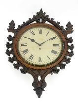 A Gothic Revival carved oak wall clock, in the style of A W N Pugin, the 12 inch white enamelled