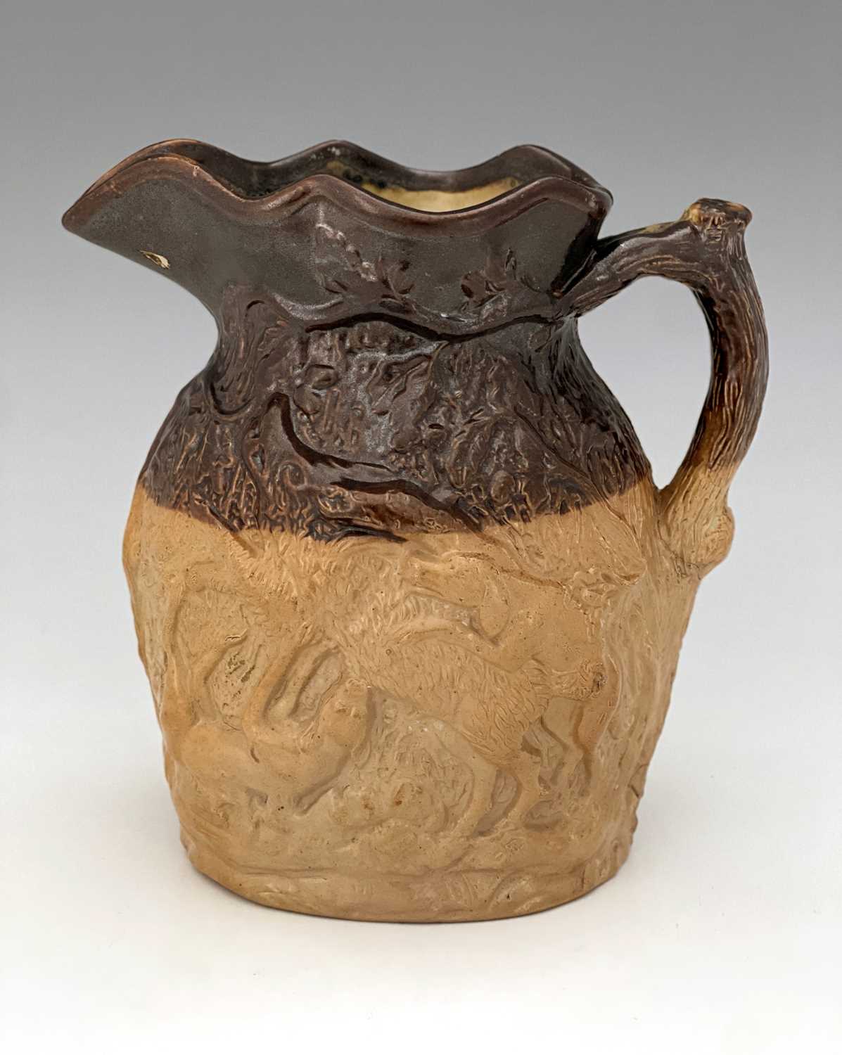 A Doulton and Watts relief moulded stoneware hunting jug, modelled to each side with dogs