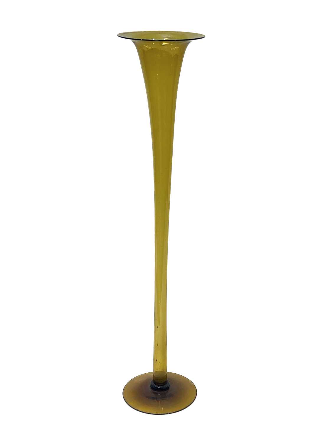 A large Arts and Crafts glass floor standing lily vase, footed trumpet form, green amber, 106cm