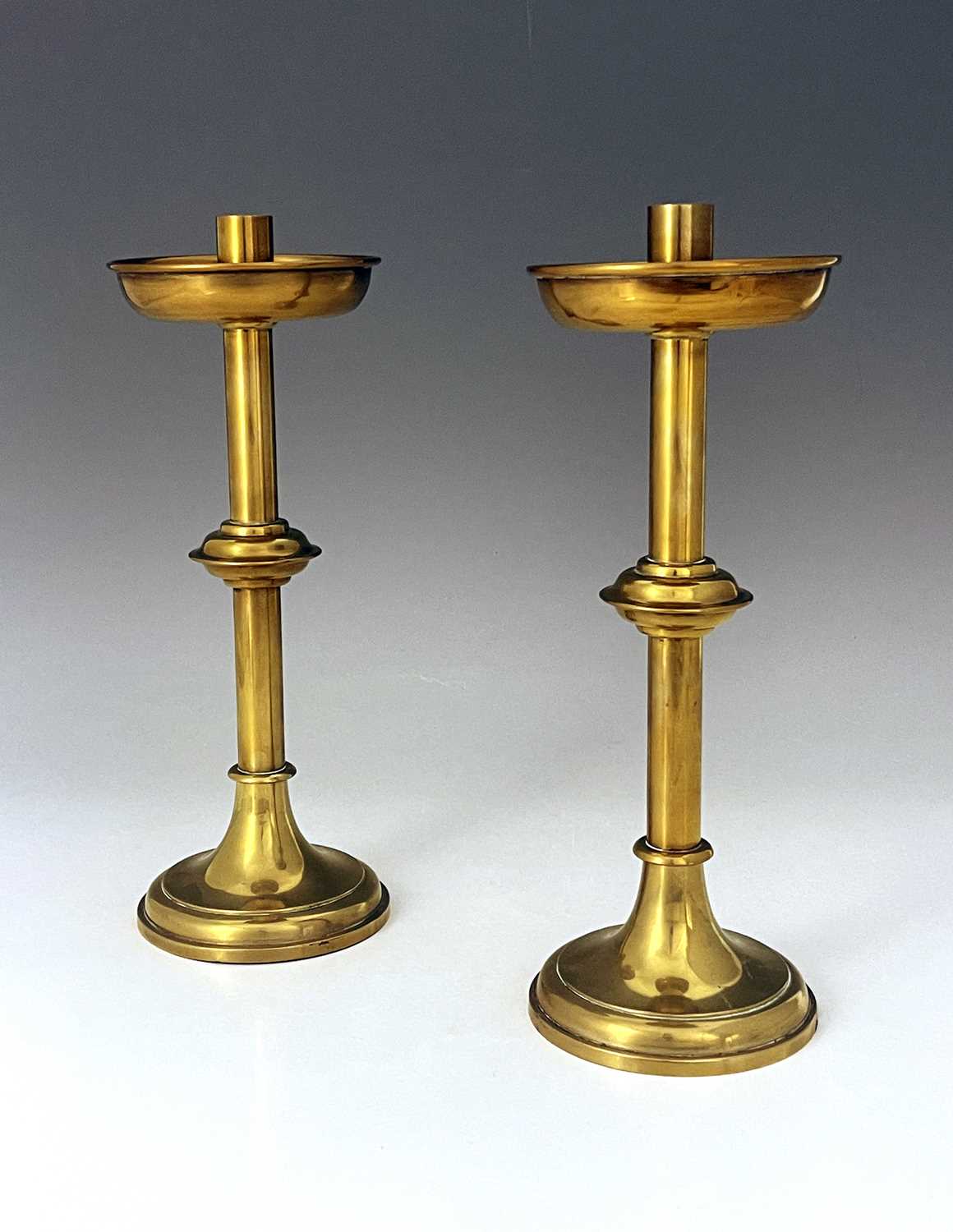 Vanpoulle of Westminster, a pair of Gothic Revival brass candlesticks, cylindrical sconces,