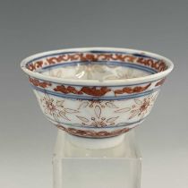 A Chinese porcelain rice grain tea bowl, decorated in iron red with auspicious motifs and
