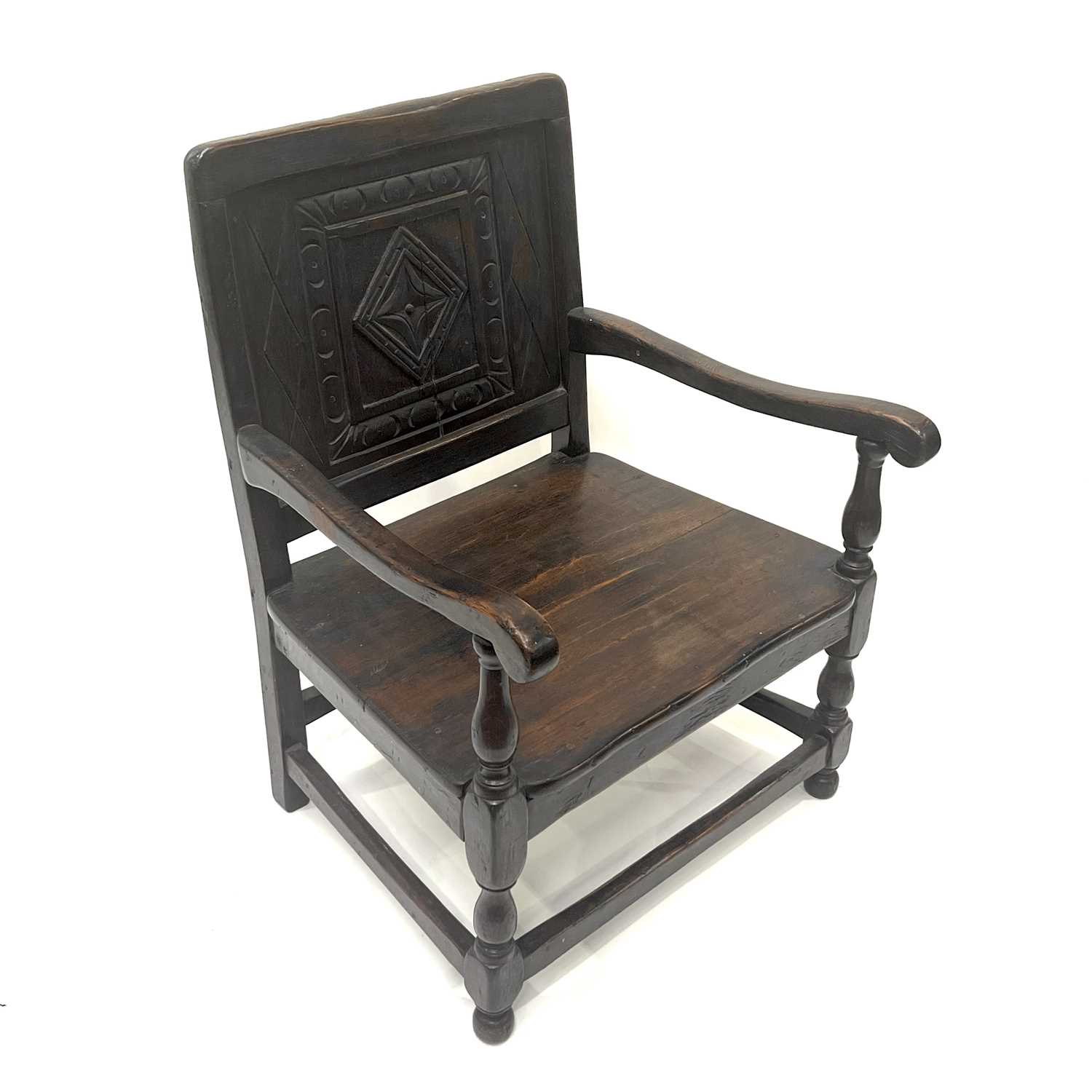A 17th Century Welsh oak child's armchair, Monmouthshire, panel back with carved lozenge within a