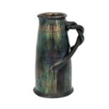 An art pottery iridescent jug, conical barrel form with incised concentric bands and bisected