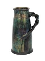An art pottery iridescent jug, conical barrel form with incised concentric bands and bisected