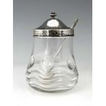 Bernard Cuzner for Liberty and Co., an Arts and Crafts silver lidded glass preserve jar and spoon,