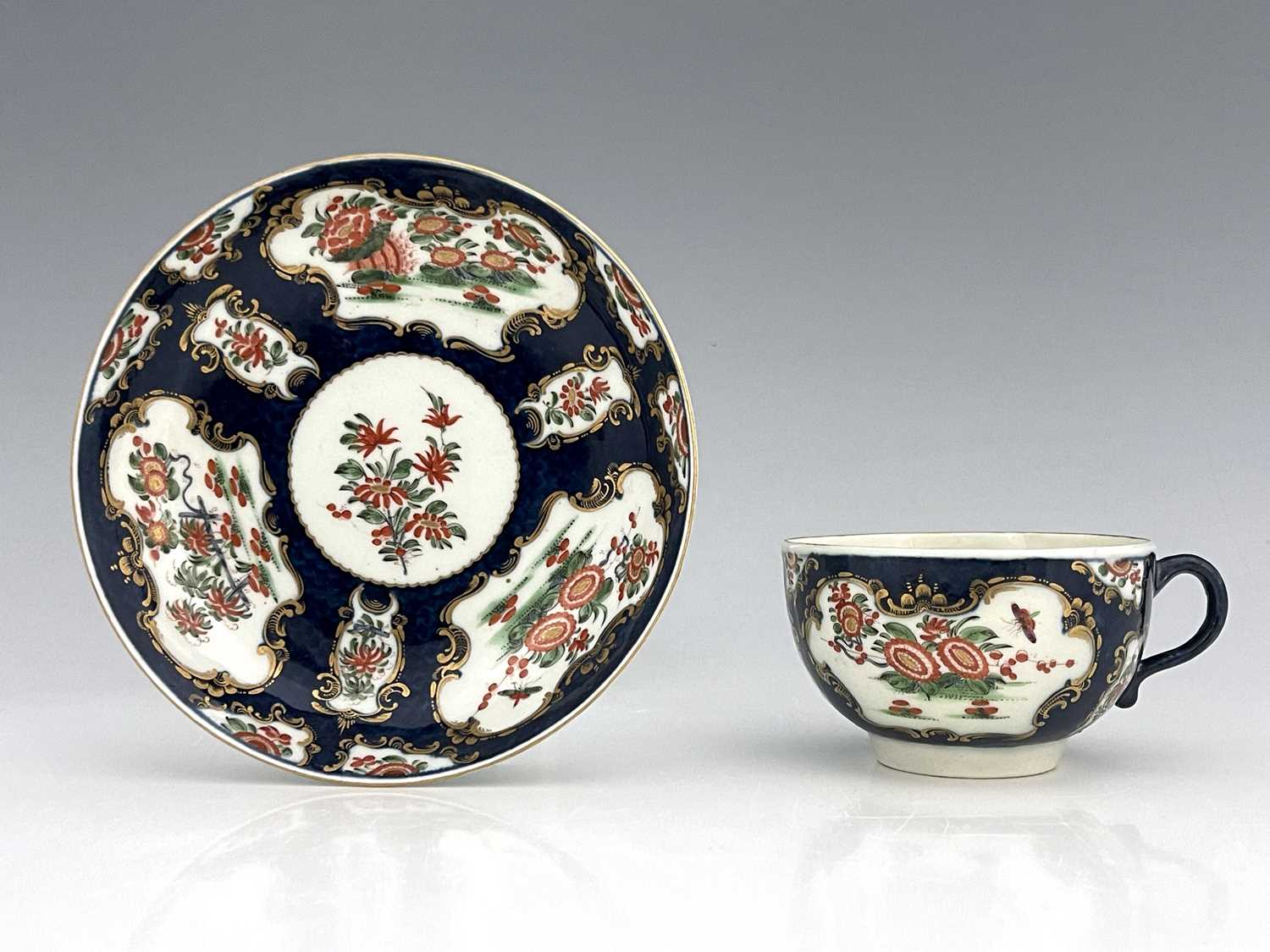 A Worcester scale blue cup and saucer, square seal mark, circa 1770, painted with chrysanthemums