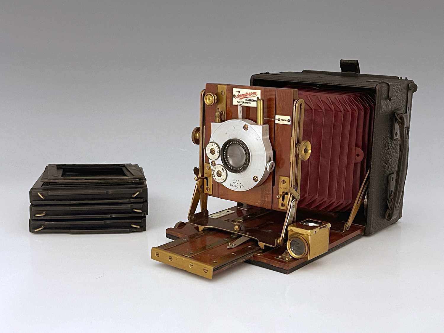 A Sanderson 4x5 Field concertina camera, red bellows, brass, and mahogany fittings with a C.P. Goerz