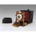 A Sanderson 4x5 Field concertina camera, red bellows, brass, and mahogany fittings with a C.P. Goerz