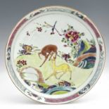 A Chinese famille rose dish, enamelled with deer in a garden landscape, within geometric and foliate