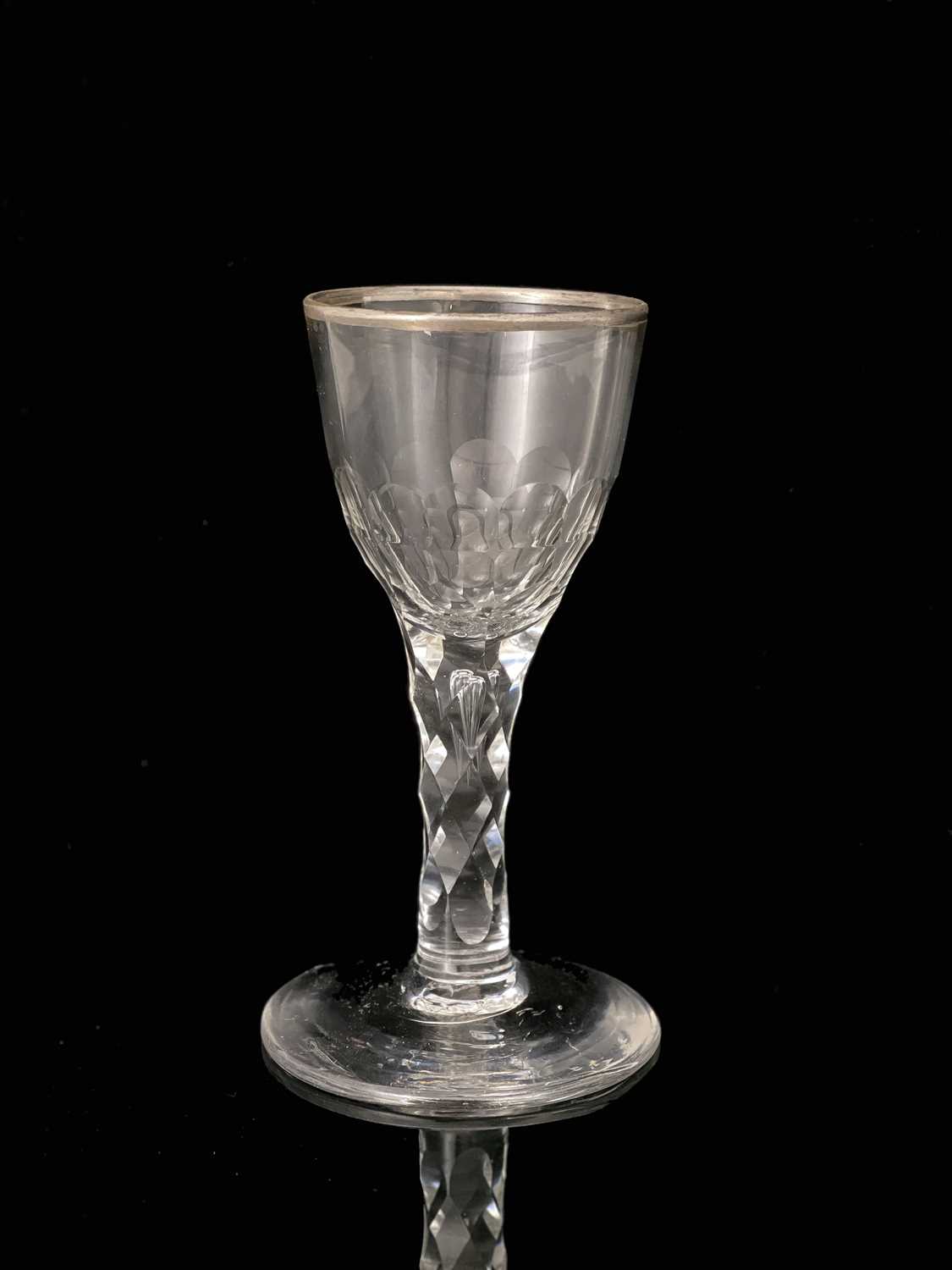 A facet stem wine glass, circa 1780, the rounded bowl with silvered rim, half cut to the lower