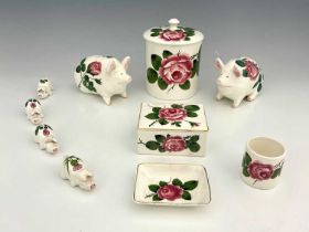 A collection of Wemyss Plicta ware, including two pig money boxes painted with cabbage roses, four