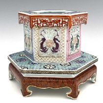 A Chinese famille rose brush pot on integrated platform stand, hexagonal section with relief moulded