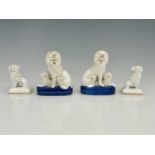 Two pairs of Staffordshire dogs, one with family groups of poodles and puppies on blue bases, the