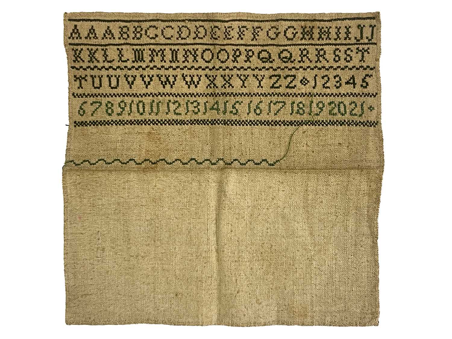 An 18th century sampler, embroidered in green with alphabet and numbers in four rows, 17cm square,