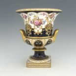 W Mosley for Royal Crown Derby, a floral painted twin handled Campana Urn, 1903, decorated with a