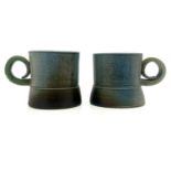 Jane Hamlyn, a pair of studio pottery salt glazed stoneware mugs, wide footed cylindrical form, with