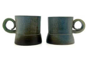 Jane Hamlyn, a pair of studio pottery salt glazed stoneware mugs, wide footed cylindrical form, with