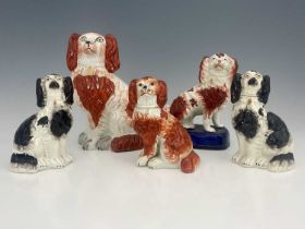 A collection of Staffordshire dog figures, 19th century, including a pair of black spotted spaniels,