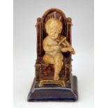 George Tinworth for Doulton Lambeth, a stoneware figural menu holder, modelled as a child playing