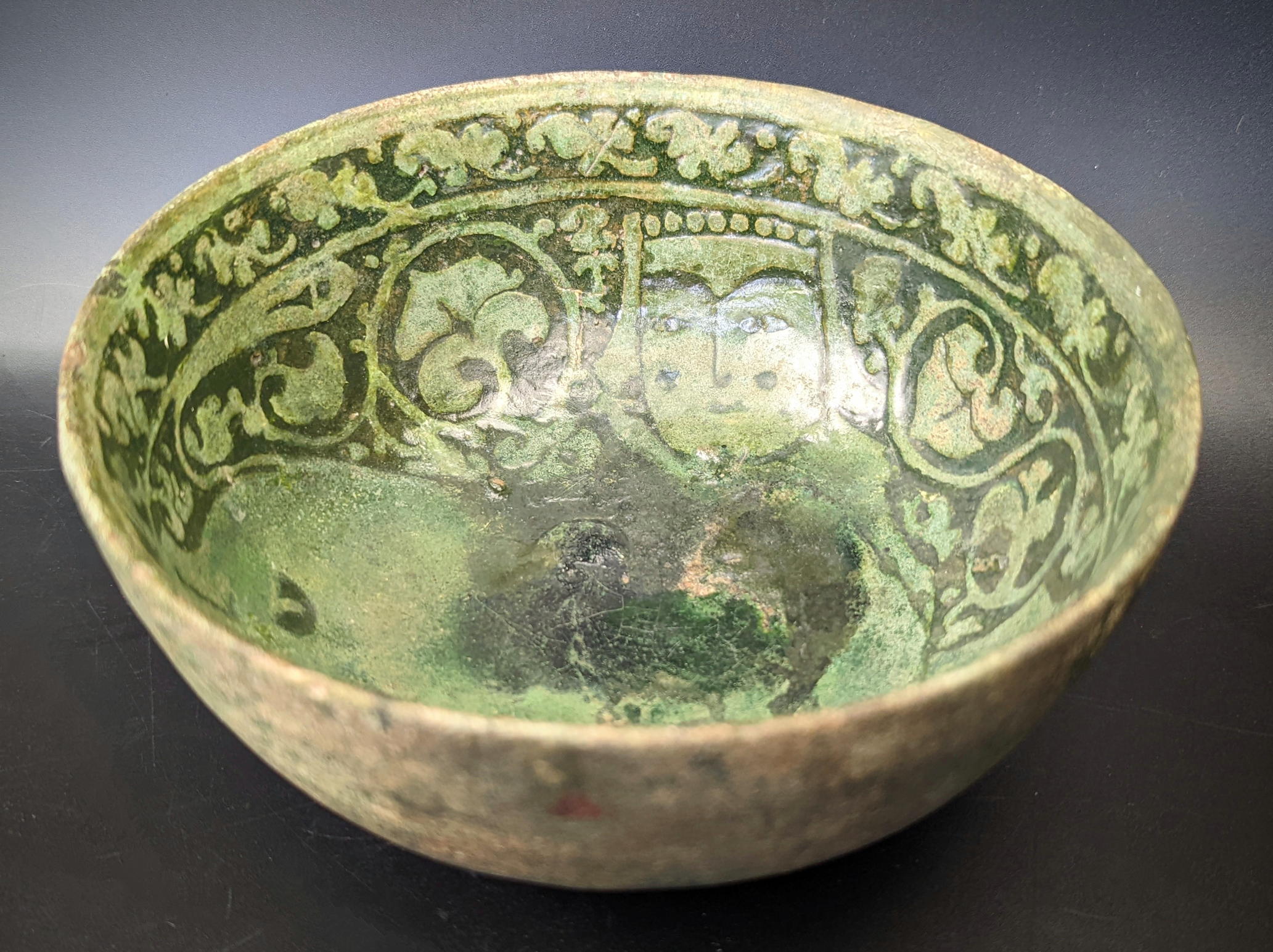 A rare 12th century Persian Garus ware green glazed pottery bowl depicting a mythical creature, H.