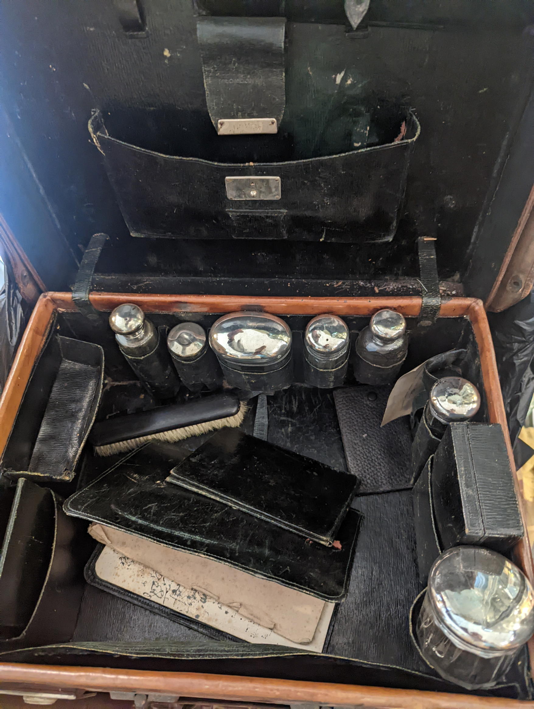 A travel vanity case with silver topped glass jars