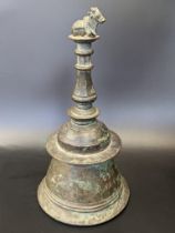 A rare 17-18th century South Indian inscribed bronze bell with a Nandi bull finial, H.23cm