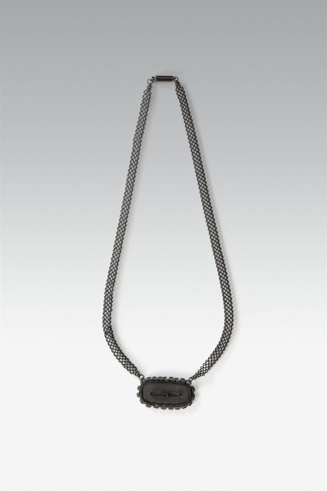 A cast iron pendant necklace with braided iron wire