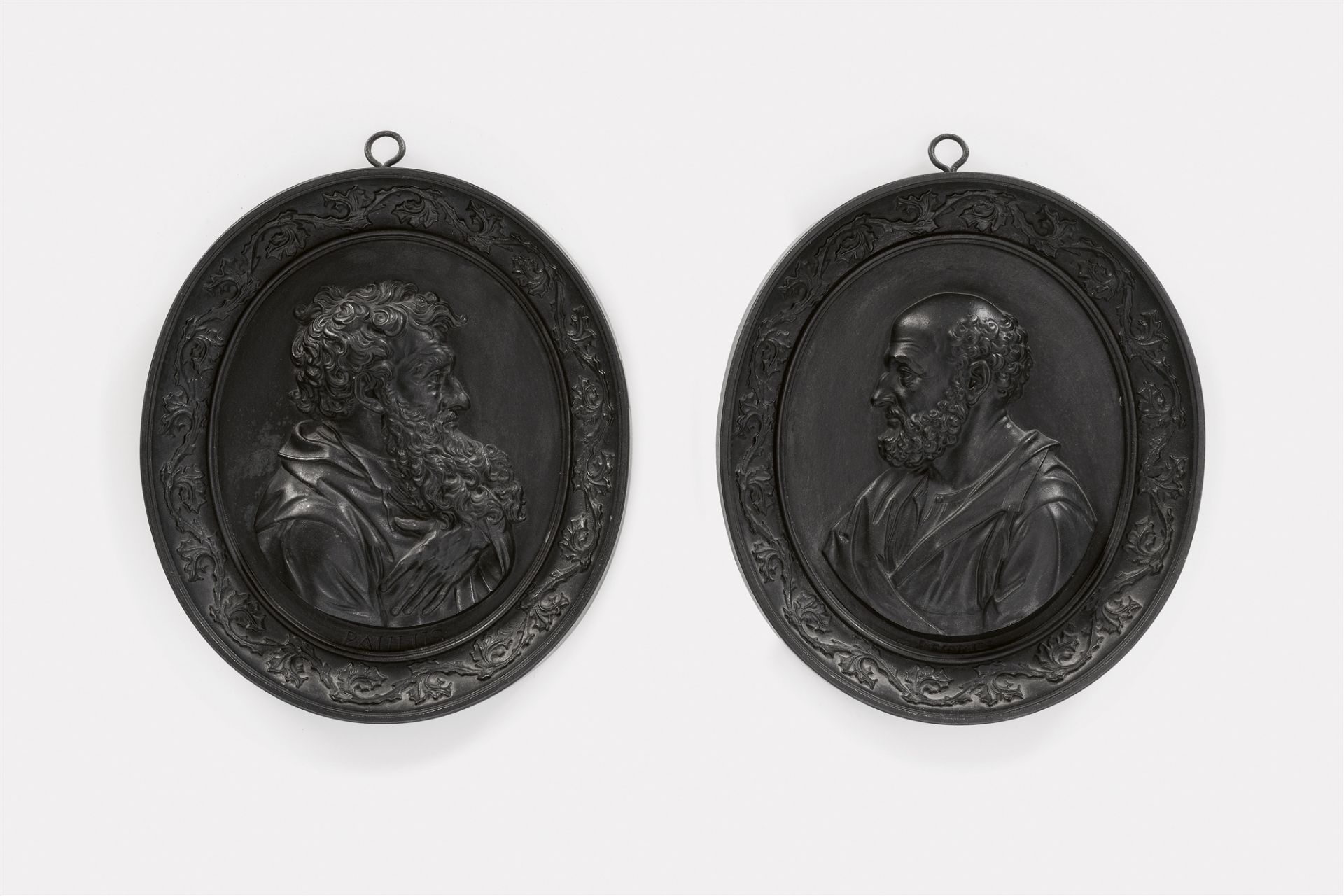 A pair of oval cast iron plaques with Sts. Peter and Paul