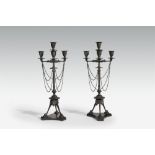 A pair of four flame cast iron candelabra