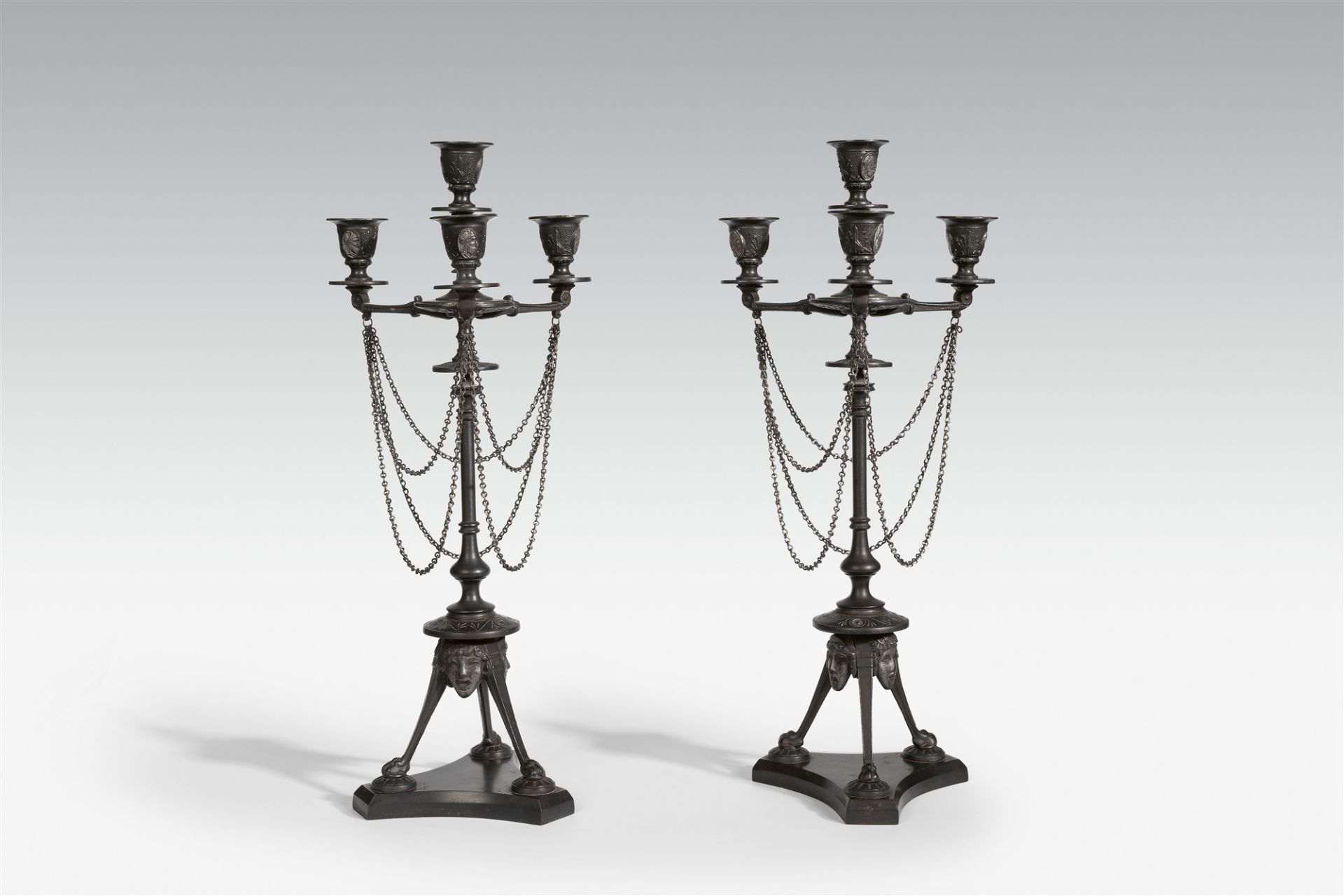 A pair of four flame cast iron candelabra