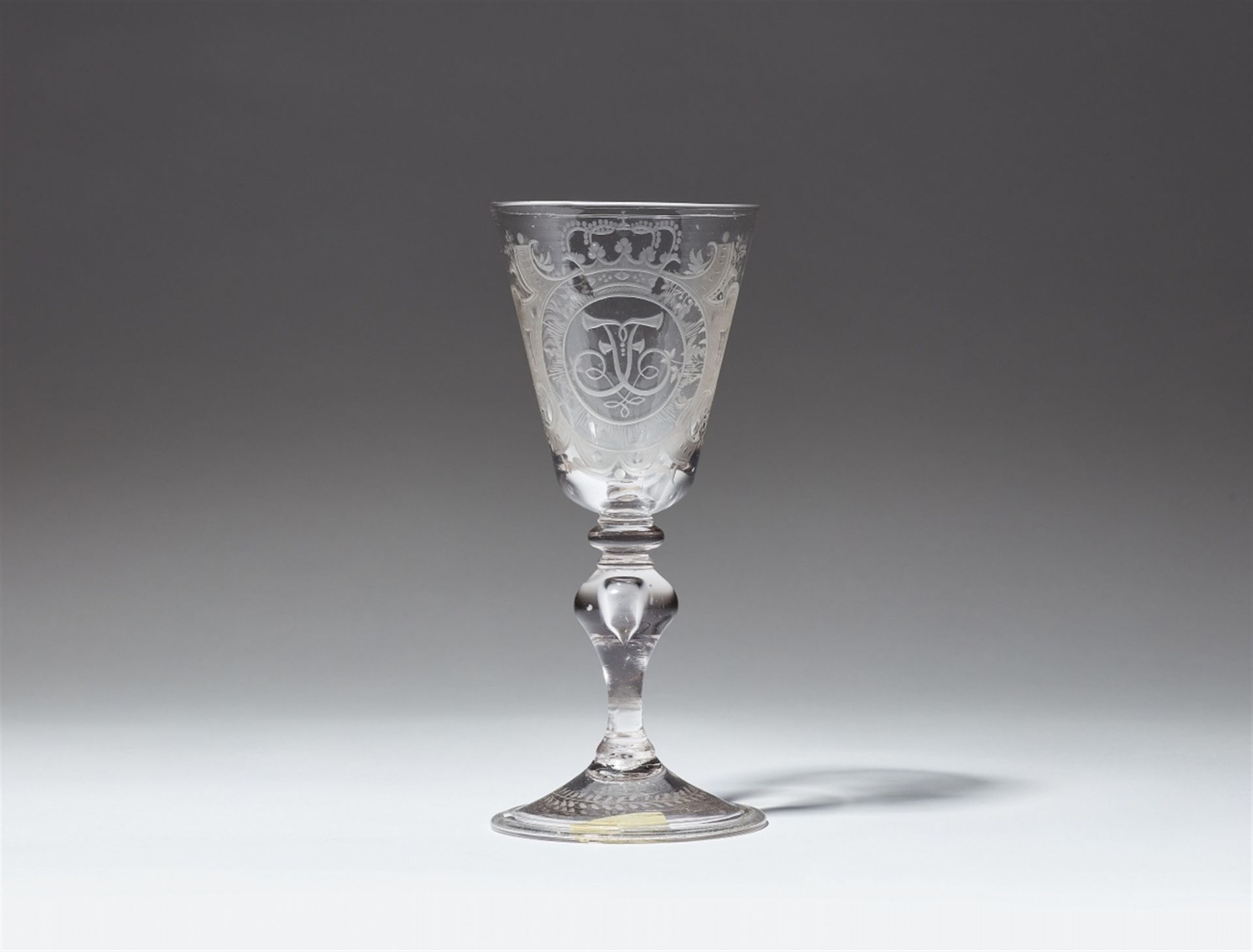 A Saxon cut and wheel engraved glass goblet with a mirrored letter F