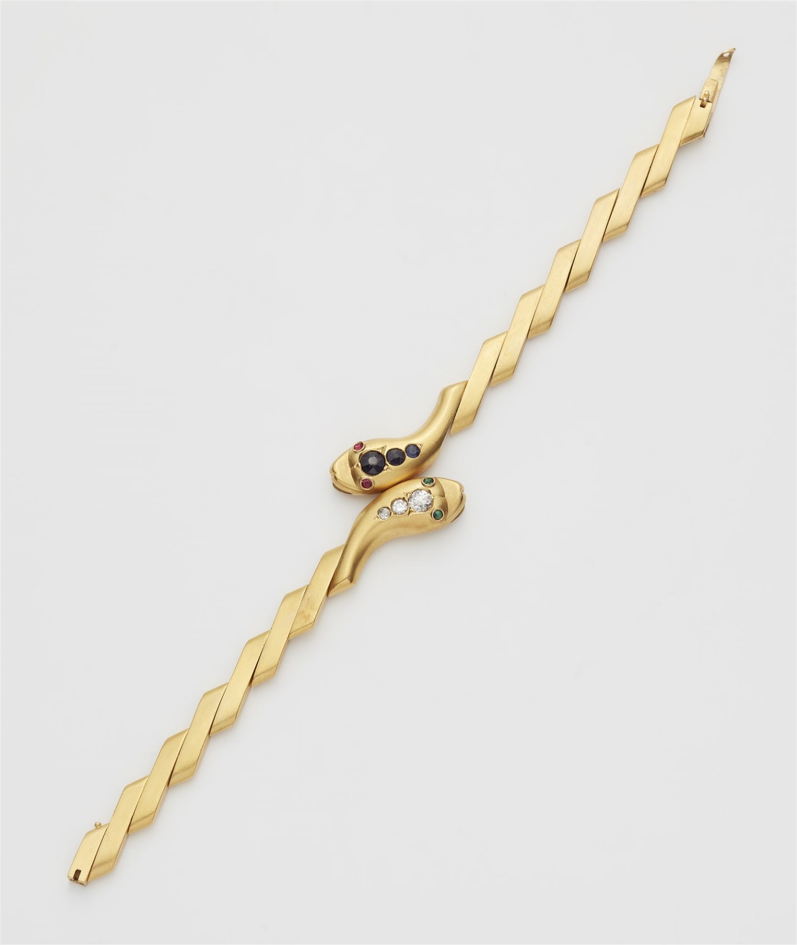 An 18k gold repoussé sapphire and diamond snake bracelet.