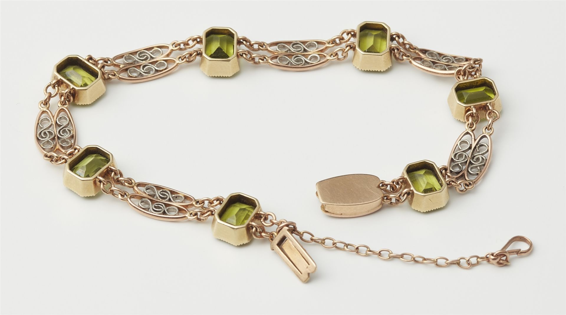 A 14k red gold platinum and peridot bracelet. - Image 2 of 2
