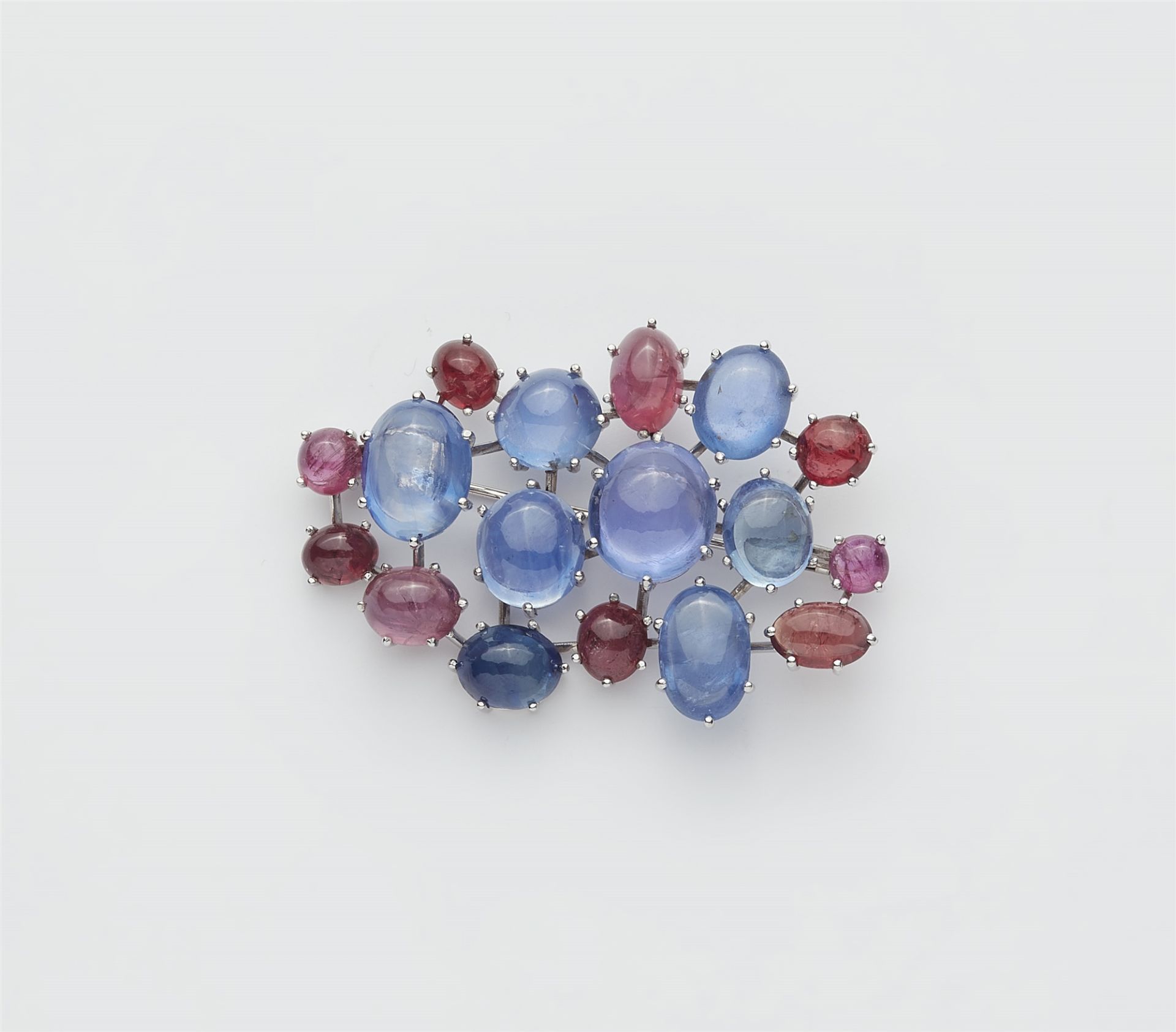 A German 18k white gold Ceylon sapphire and ruby cabochon brooch.