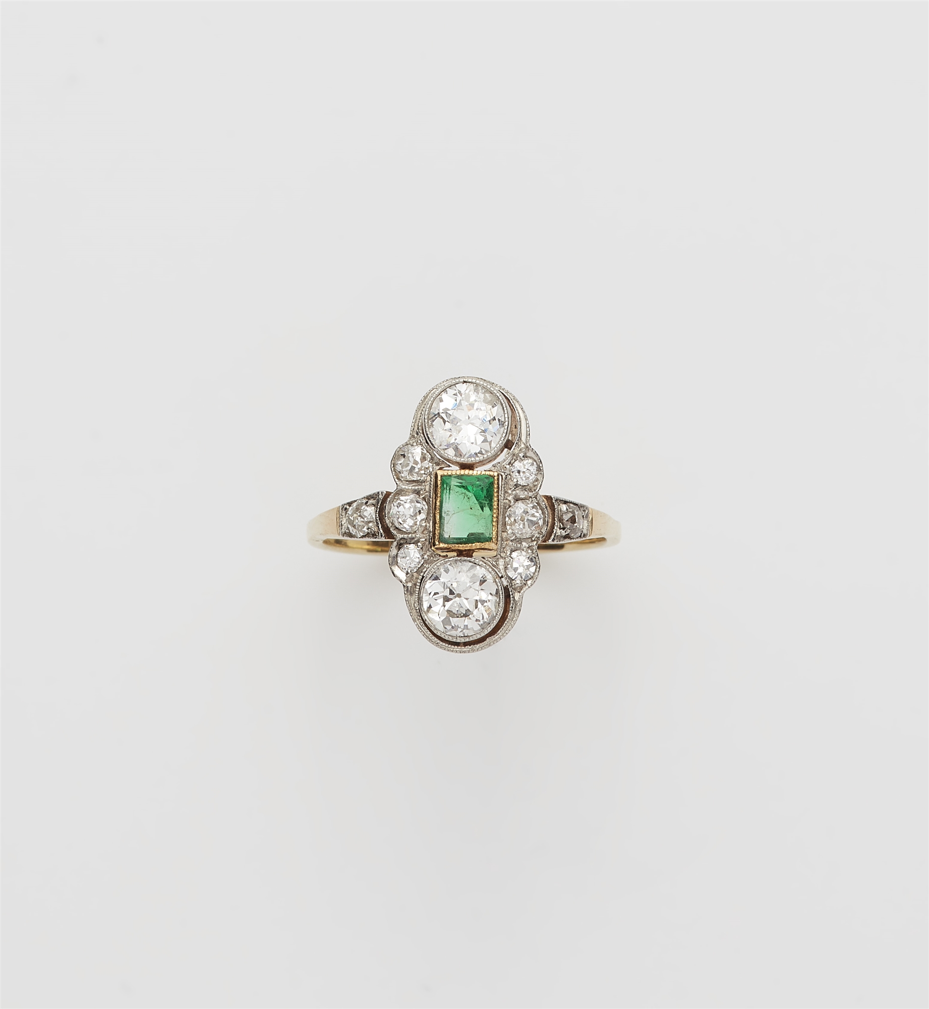 An Art Déco 14 kt gold platinum diamond and emerald ring.